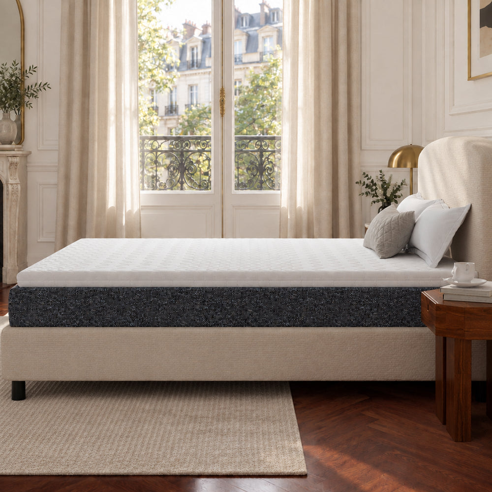 Helles Gästezimmer mit bequemem Bett und Topper